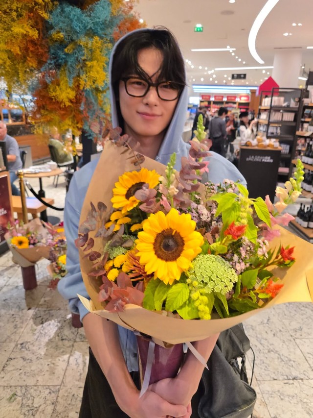 Jooyeon, holding a bouquet with a bright smile... 